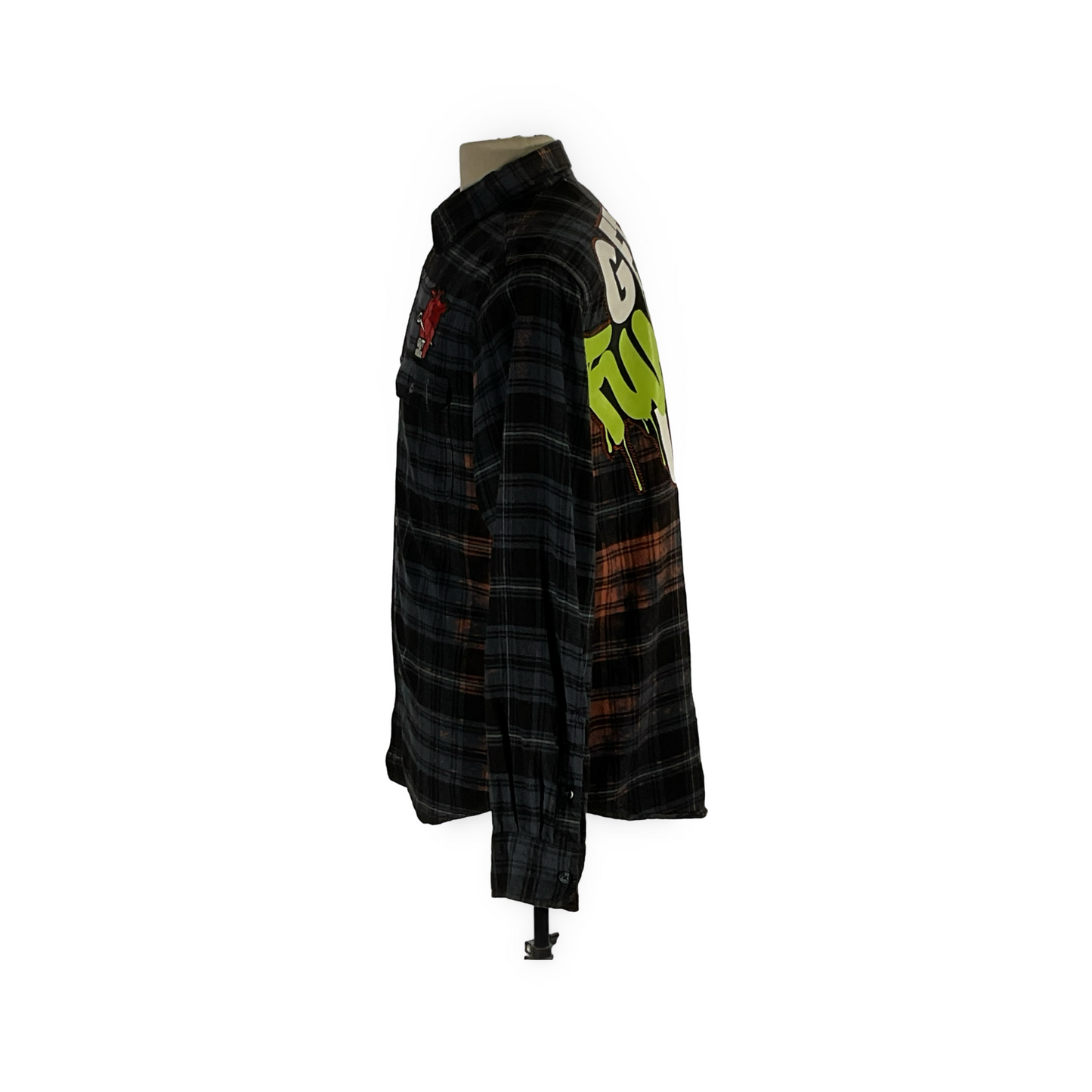 Plaid flannel shirt with green cartoon, metal studs, and hand-patched details, embodying sustainable fashion. Titled GET FUNKED UP, it showcases a unique, vintage aesthetic.