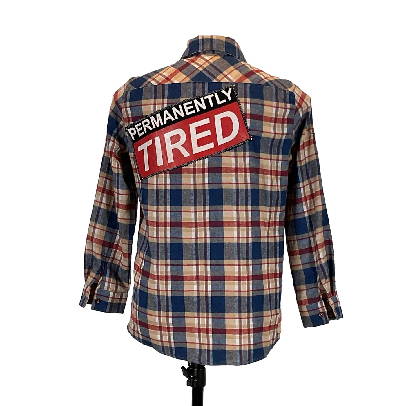 PERMANENTLY TIRED Men's Custom Long-Sleeve Flannel Shirt featuring a plaid pattern and distinctive back patch design. Medium size, emphasizing bold, unique craftsmanship by DEVIOUS SAINT.