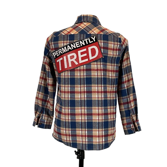 PERMANENTLY TIRED Men's Custom Long-Sleeve Flannel Shirt featuring a plaid pattern and distinctive back patch design. Medium size, emphasizing bold, unique craftsmanship by DEVIOUS SAINT.