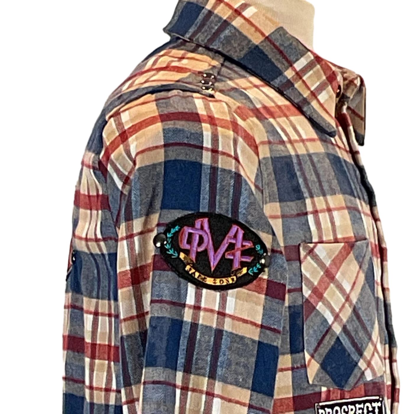 Close-up of the PERMANENTLY TIRED Men's Custom Long-Sleeve Flannel Shirt featuring black patch with purple letters, showcasing its unique tartan pattern.