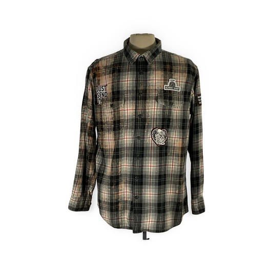 Cyber Bear plaid shirt on mannequin, showcasing hand-patched details and metal studs, reflecting a unique, sustainable, and vintage-inspired design by DEVIOUS SAINT.