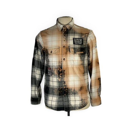 Close-up of the unique Cyber Bear flannel, showcasing hand-patched details, metal studs, and a bleached finish, epitomizing sustainable, bold fashion from reclaimed cotton.
