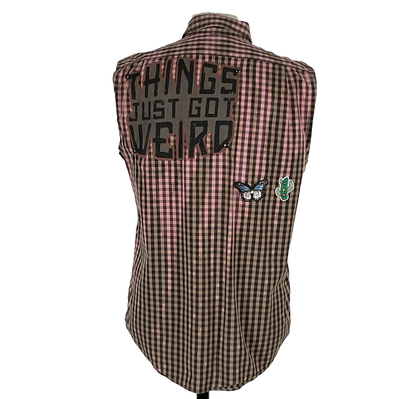 THINGS JUST GOT WEIRD Men's Custom Sleeveless Shirt on a mannequin, showcasing unique patches including a butterfly and cactus design on plaid fabric.