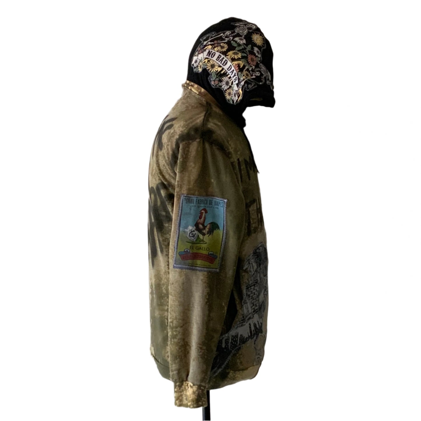I’M NOT THE DREAM hoodie: olive-green with floral motif, No Bad Days slogan, El Gallo patch, bold style, large size, side-profile view.