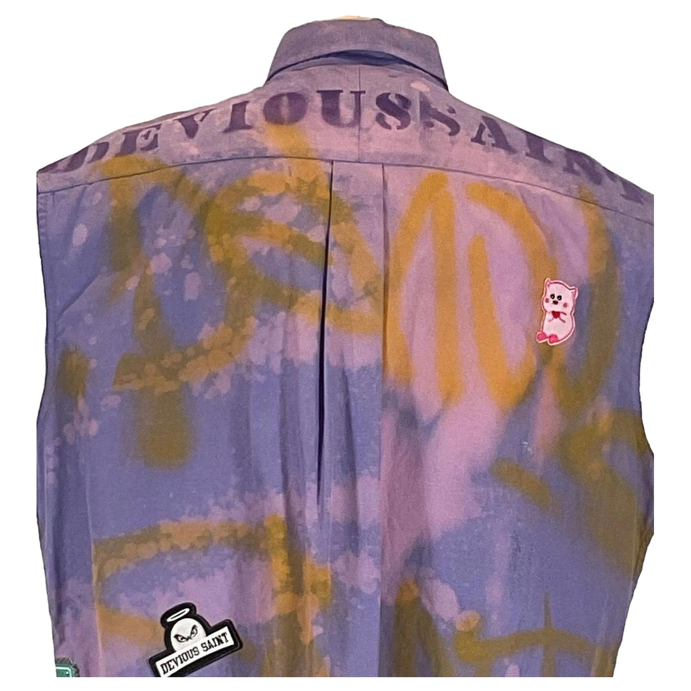 Close-up of a DEVIOUS SAINT Men's Custom Sleeveless Shirt with distinctive patch featuring a face and halo, emphasizing unique wearable art design.