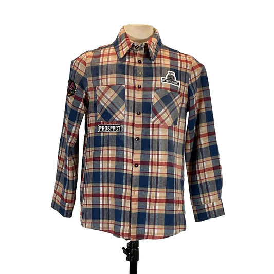 PERMANENTLY TIRED Men's Custom long-Sleeve Flannel Shirt on mannequin, featuring plaid pattern with patches, embodying DEVIOUS SAINT's bold, distinctive wearable art style.