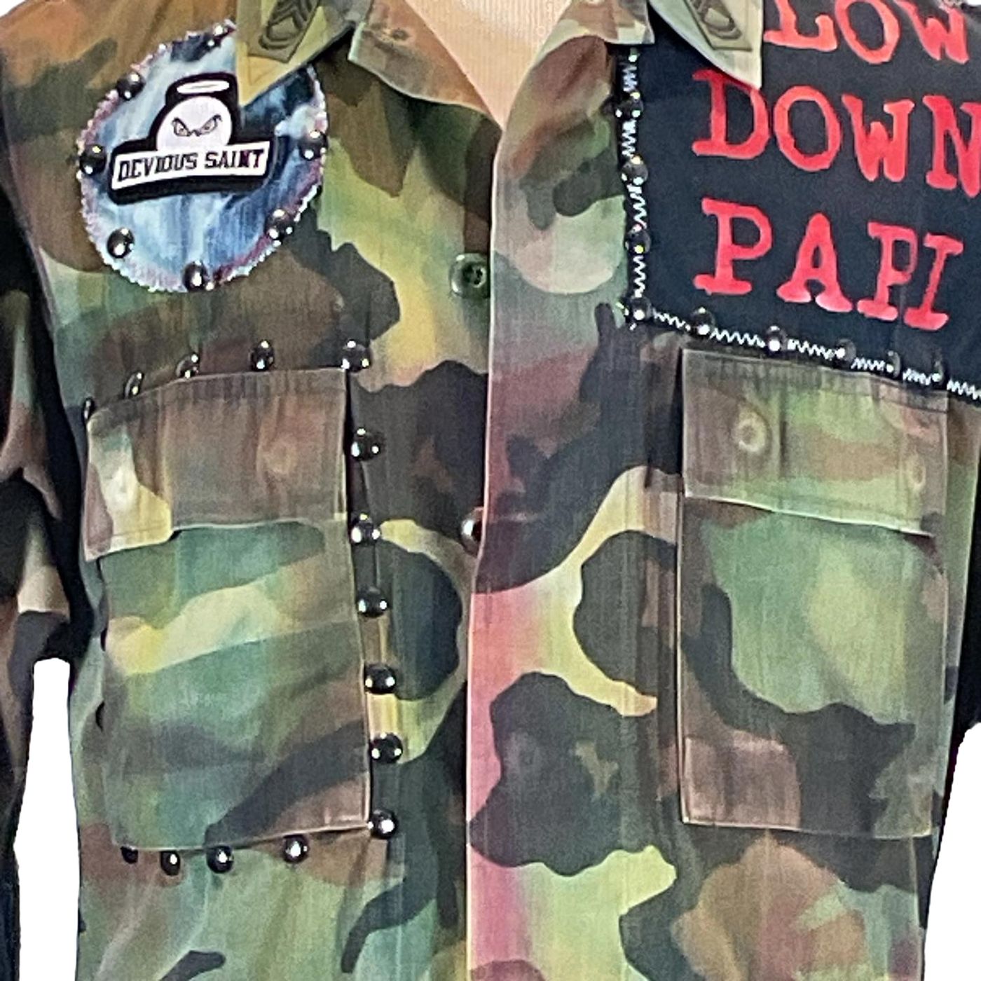 BUITRES Men's Custom Jacket by Devious Saint: Camouflage shirt adorned with distinctive patches and rhinestones, emphasizing unique wearable art. Size Large, 100% cotton.