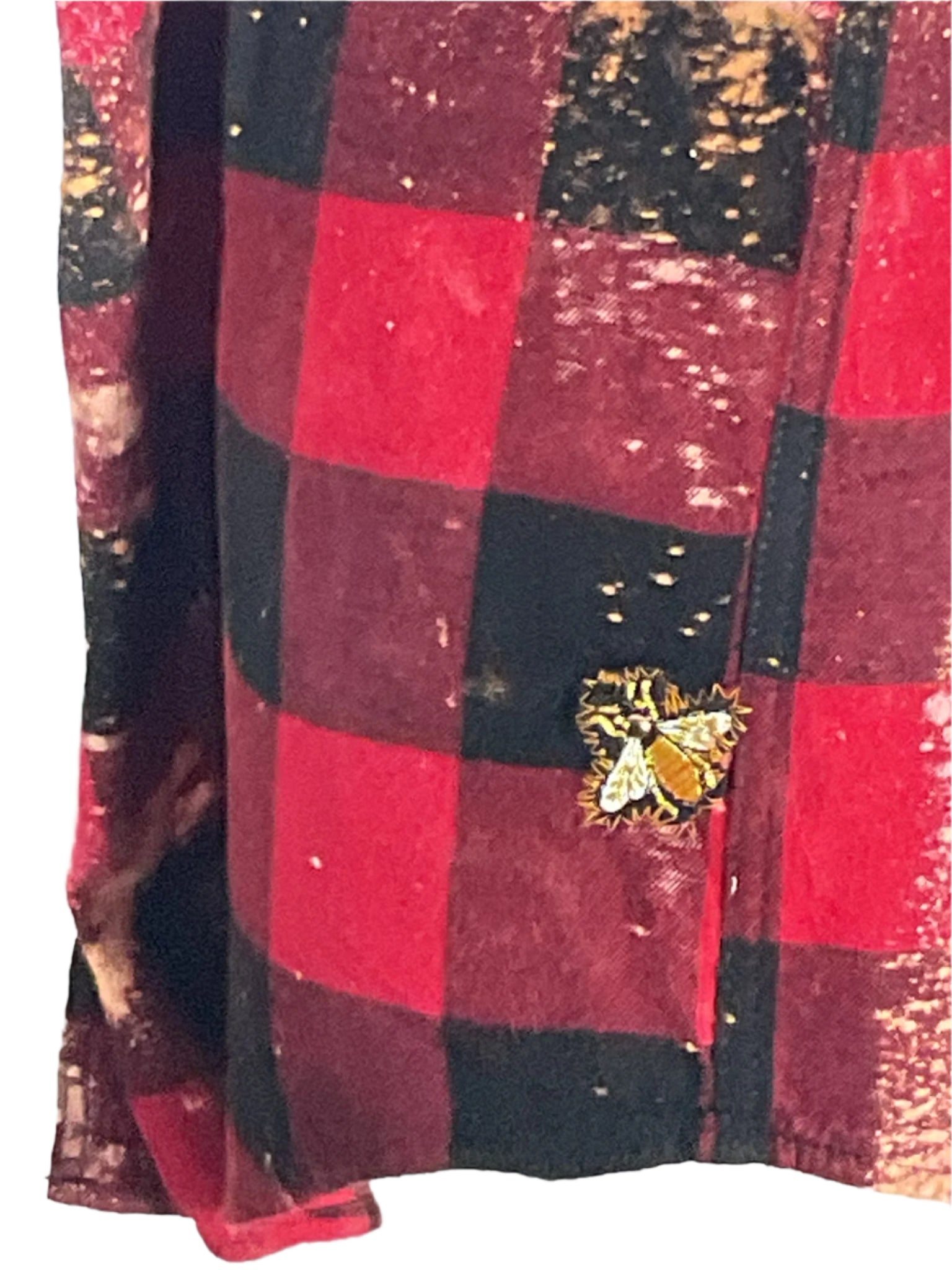 Red and black plaid flannel shirt adorned with a gold insect pin, embodying the bold, rebellious spirit of DEVIOUS SAINT's unique, wearable art style.