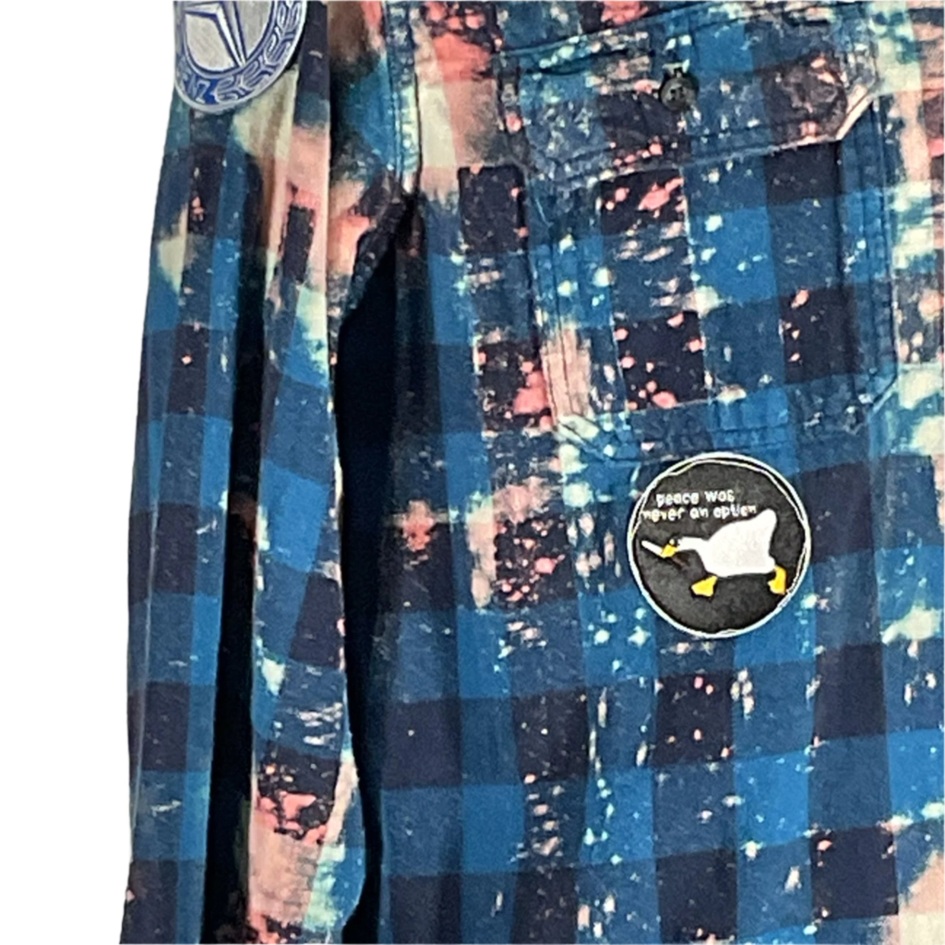 Men's blue and pink plaid flannel shirt with patches and BE KIND message, embodying DEVIOUS SAINT's unique, bold style in wearable art.