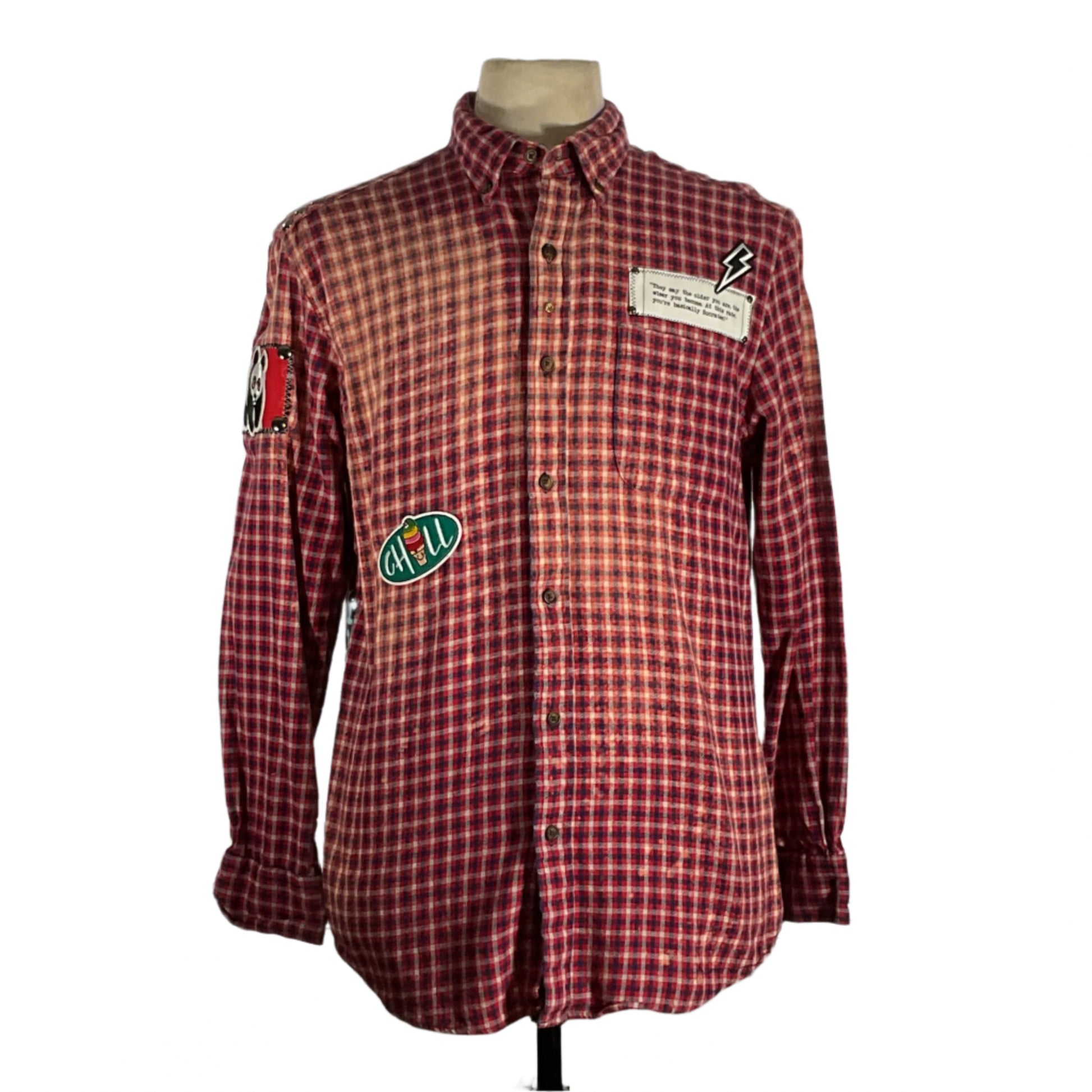 Red plaid shirt with patches and metal studding, showcasing a unique, vintage style and sustainable design from DEVIOUS SAINT's distinctive wearable art collection.
