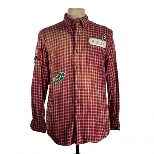 Red plaid shirt with patches and metal studding, showcasing a unique, vintage style and sustainable design from DEVIOUS SAINT's distinctive wearable art collection.