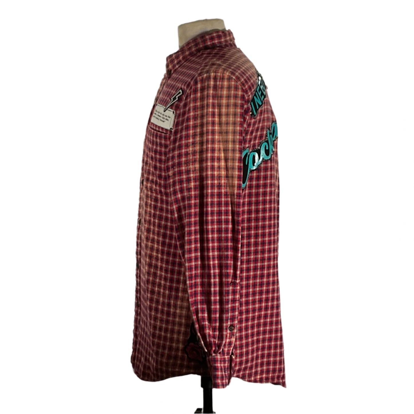 Mannequin displaying I Need a Cocktail flannel shirt, featuring bleached treatment and hand-patched details, exemplifying sustainable, vintage-inspired fashion by Devious Saint.