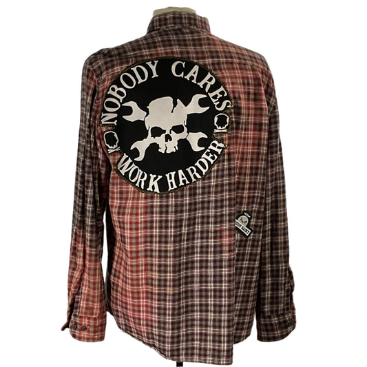 NOBODY CARES | Men's Custom Long-Sleeve Flannel Shirt featuring skull and crossbones, wrench patch, and silhouette motifs, embodying DEVIOUS SAINT's bold, distinctive style.