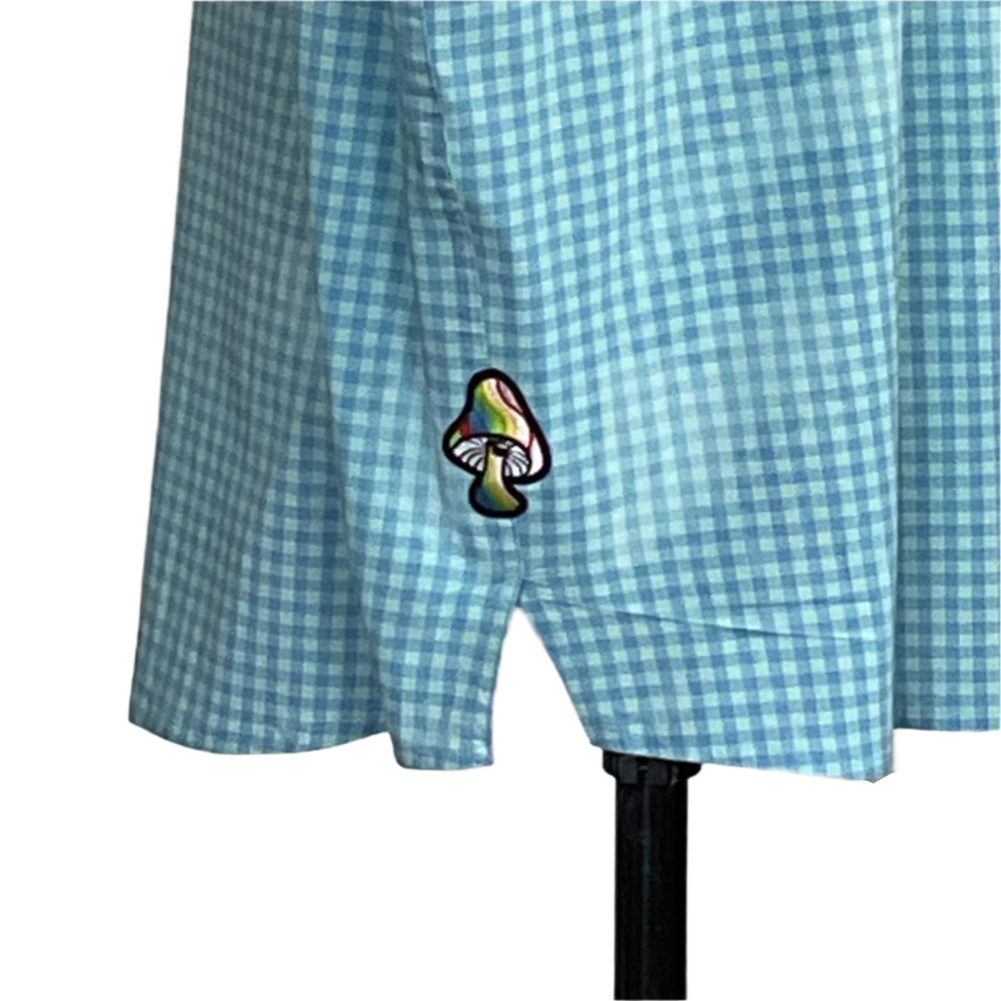 Light-blue gingham skirt with a rainbow mushroom patch near the hem on a dress form, part of the WARNING: YOU COULD GO BLIND… collection by DEVIOUS SAINT.