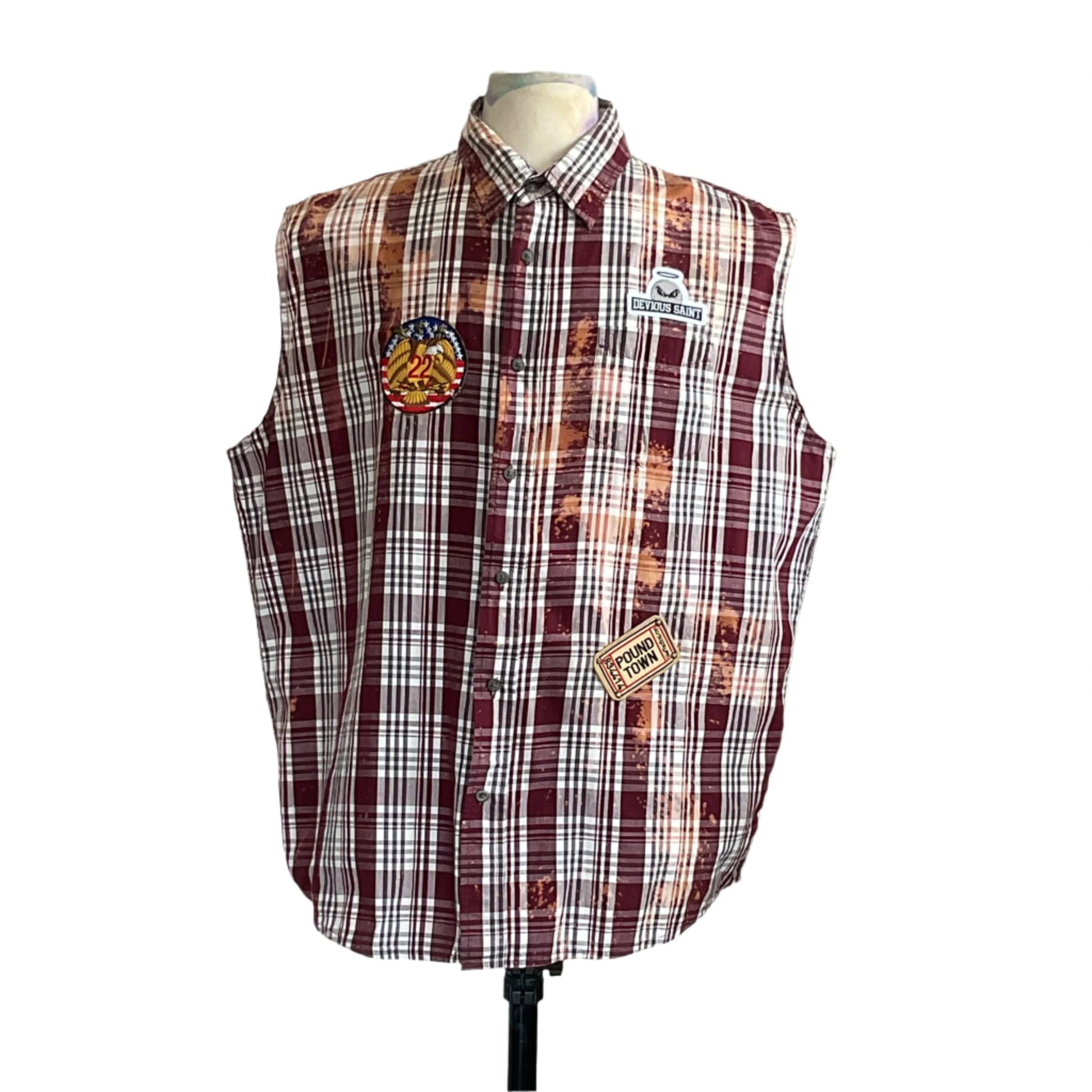 MASKED MONA LISA sleeveless plaid shirt with bleach splatters, eagle patch, and DEVIOUS SAINT branding, displayed on a mannequin.