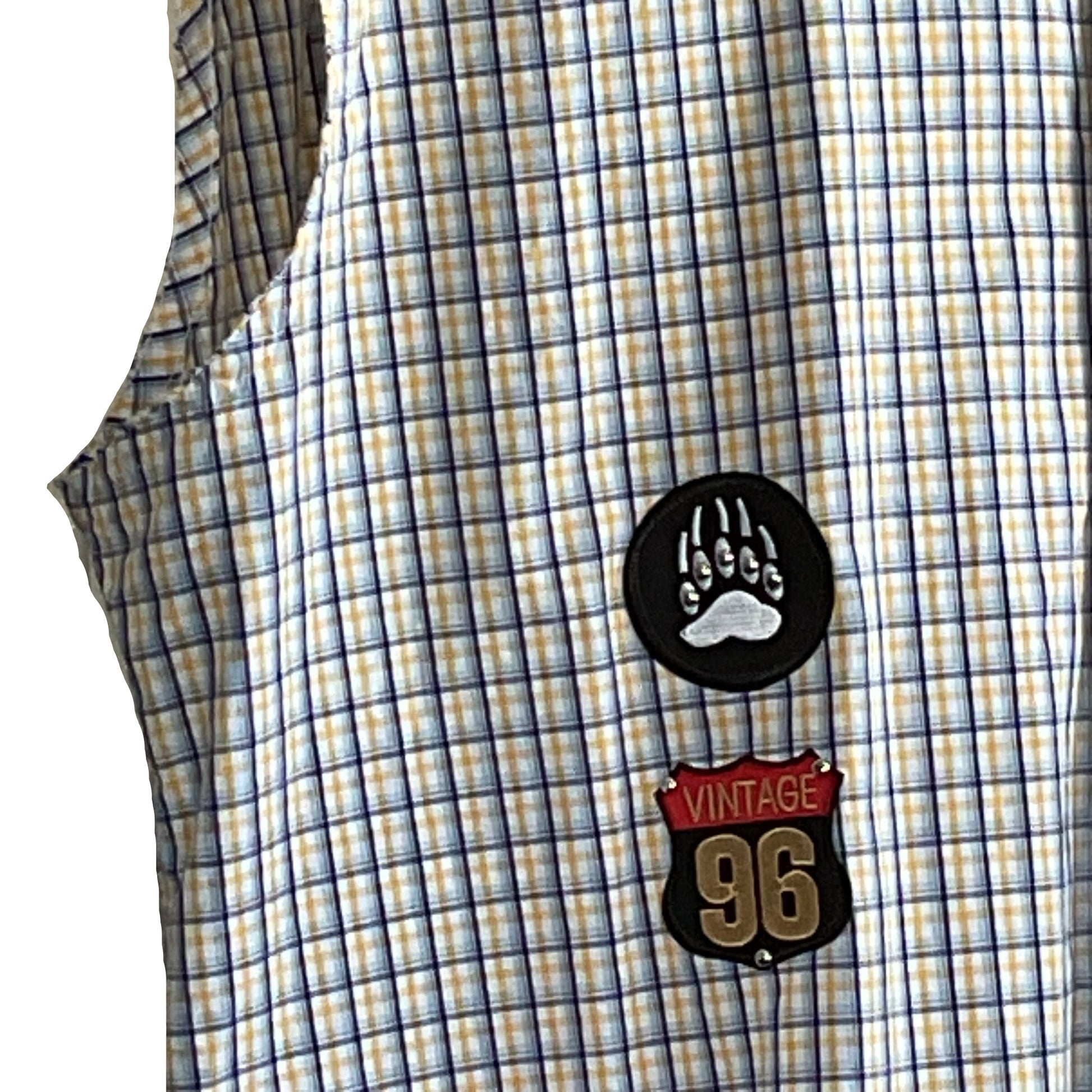 Close-up of a sleeveless blue-and-yellow plaid shirt with bear paw and VINTAGE 96 patches, showcasing unique automotive-inspired design in 4 XL size.