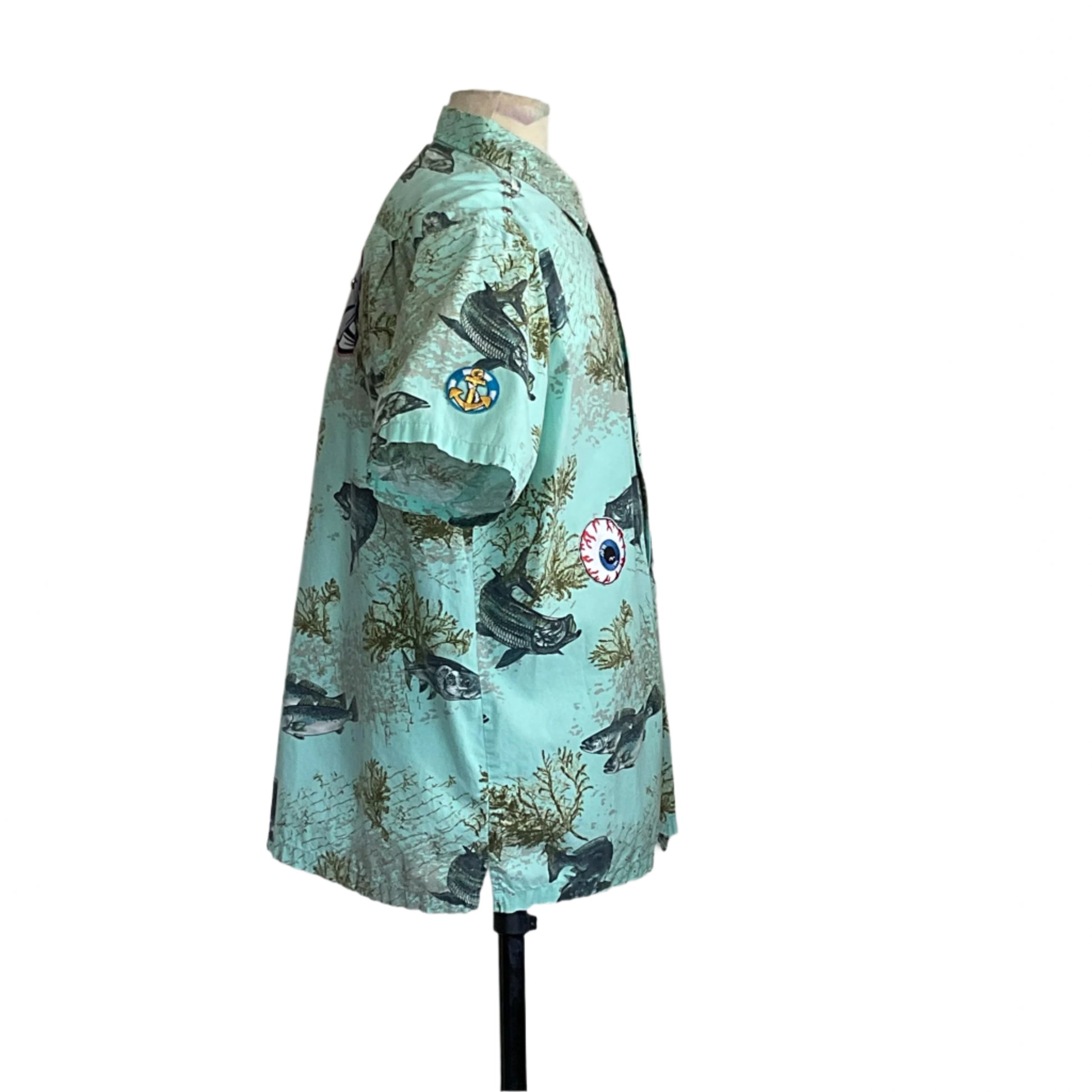 AQUA BONE FISH | Men's Custom BEAR SIZE Short Sleeve Shirt | EXTRA LARGE, featuring fish and seaweed illustrations with anchor and eyeball patches on a mannequin stand.