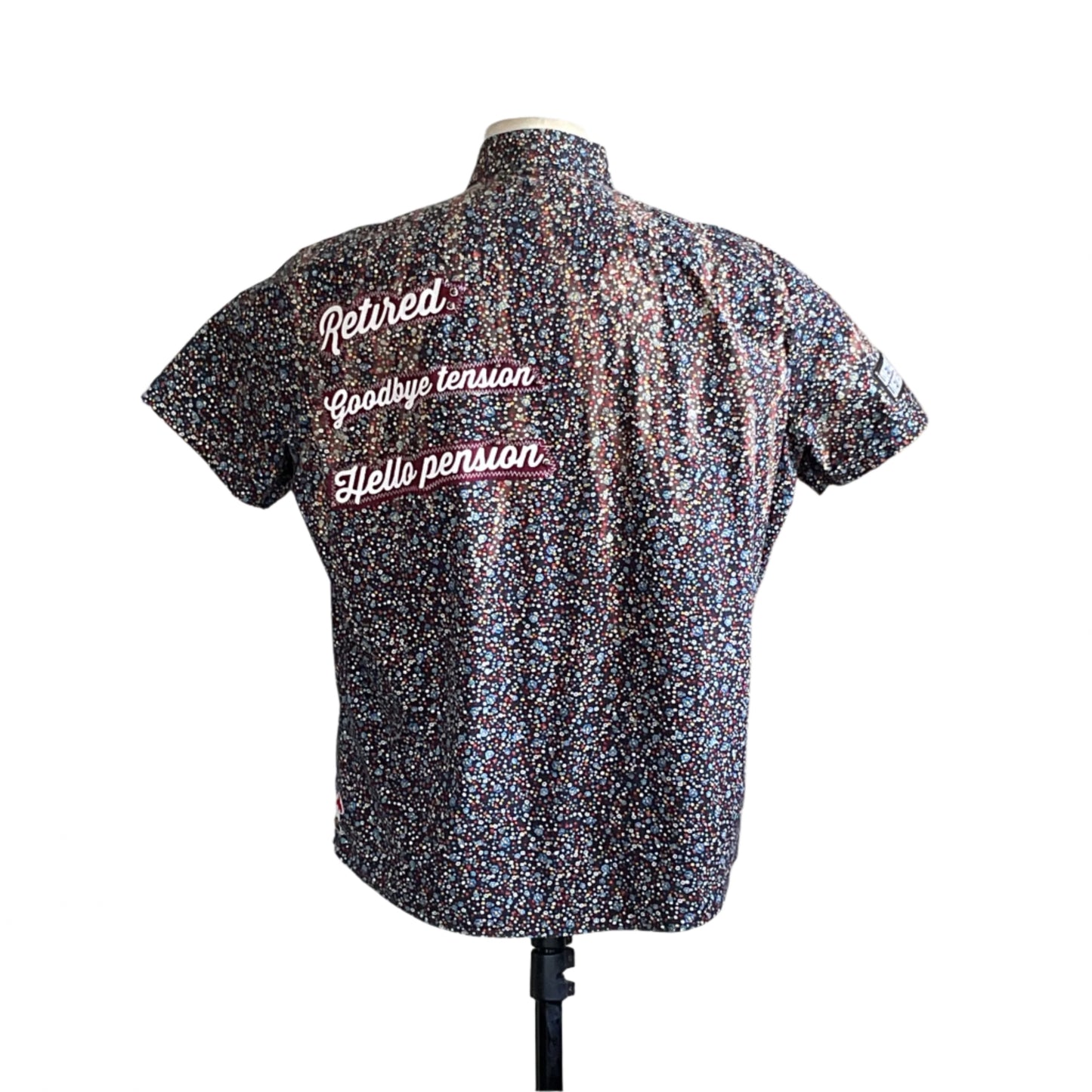 Back view of RETIRED men's custom short sleeve shirt, XL, with multicolored confetti print and contrasting script text, symbolizing leisure and strength.