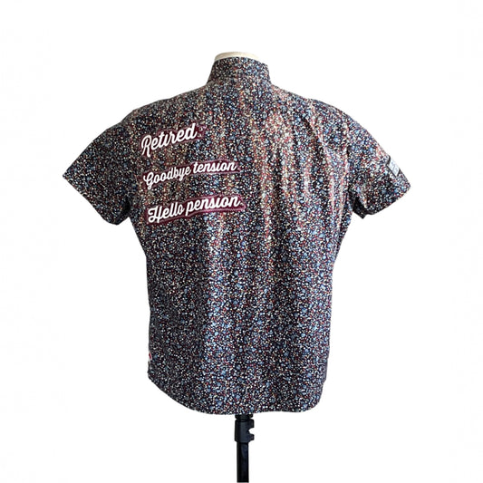 Back view of RETIRED men's custom short sleeve shirt, XL, with multicolored confetti print and contrasting script text, symbolizing leisure and strength.