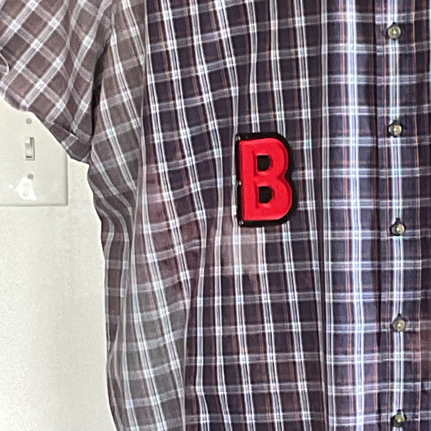 GAME BOY | Men's Custom BEAR SIZE 5 XL Shirt featuring a red B patch, hanging on a wall. Distinctive plaid design, short sleeves.